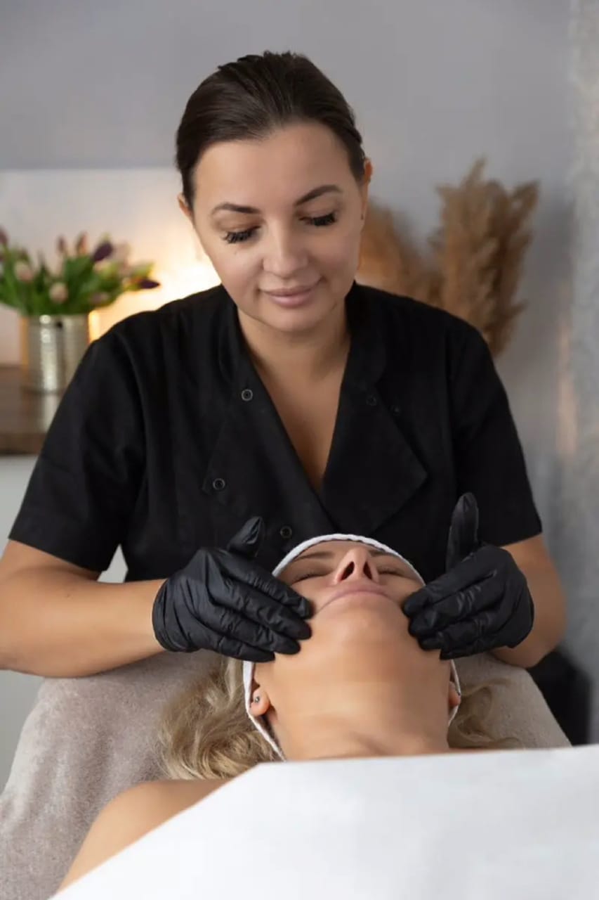 Kosmetyczka wykonuje masaż twarzy - rozluźniający