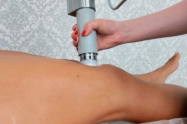 glowica podajaca fale akustyczna przylozona do ciala - kosmetyczka w trakcie zabiegu