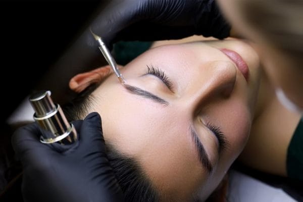 Beautician performs powder henna on client's eyebrows Maris beauty salon