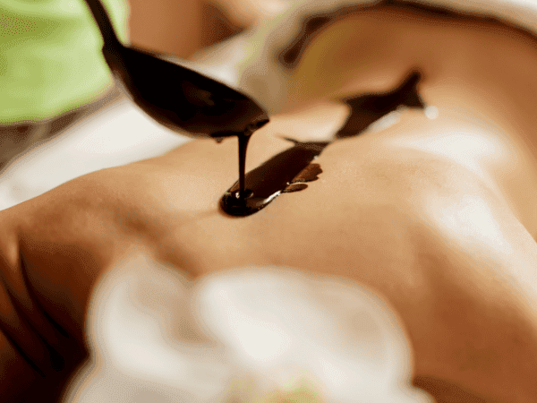 masażysta polewa plecy czekoladą
