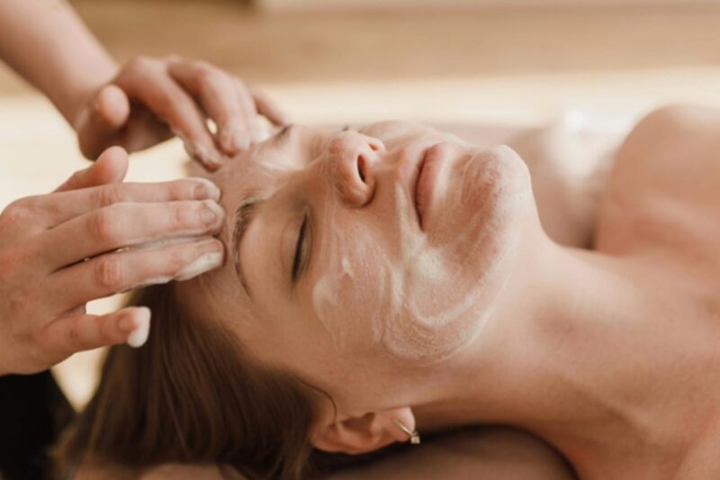 The beautician massages the product into the skin of the face