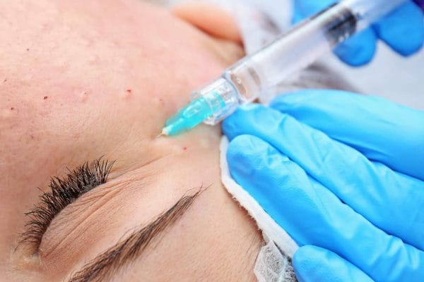 The beautician injects the preparation under the eye of the client